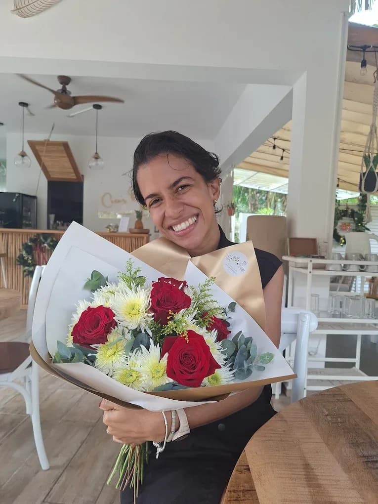 Clienta sonriente con un ramo de rosas en Evy Spa