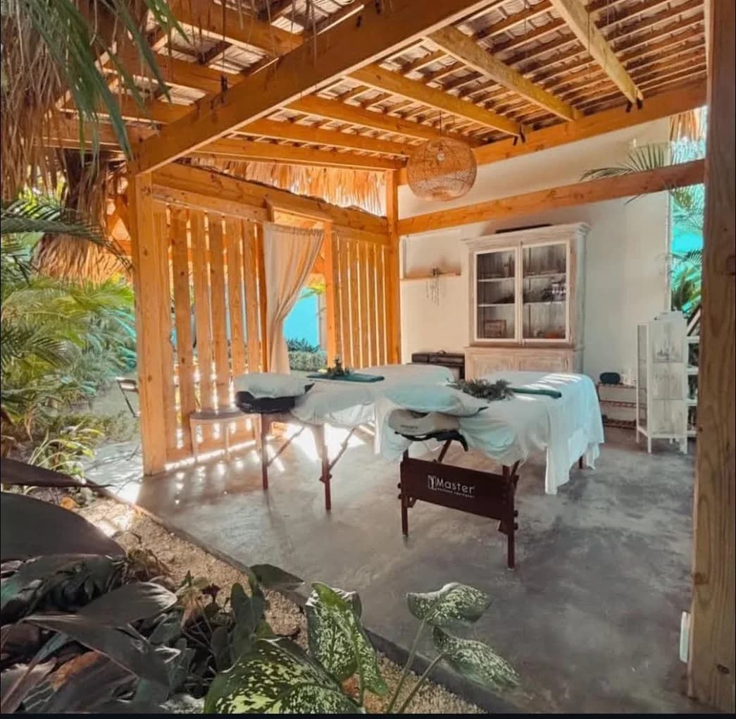 Sala de masaje abierta con techo de madera y vista al mar